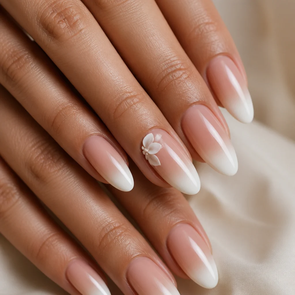 Almond nails with a white blooming tip and a small sculpted 3D gel flower at the cuticle corner