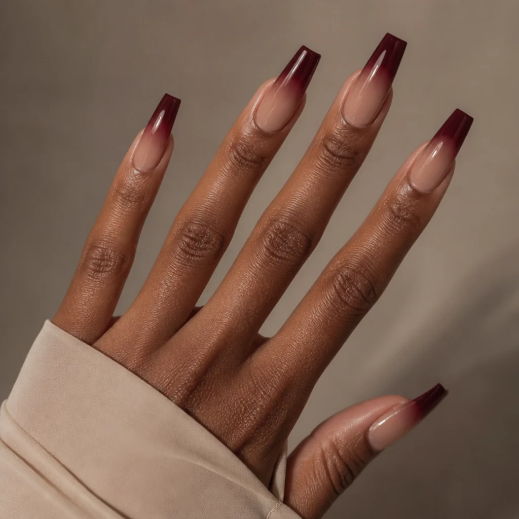 Long coffin nails with a deep berry-wine blooming gel french tip fading into a soft nude