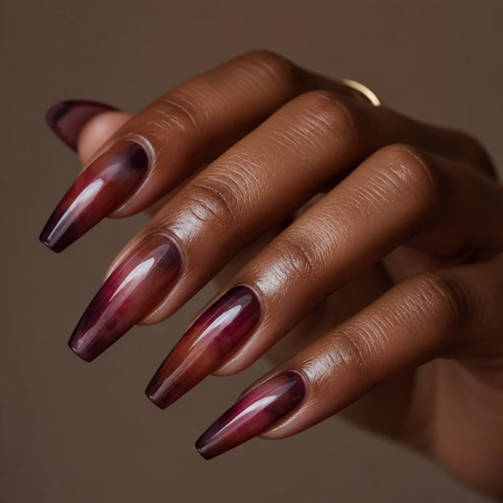 Long coffin nails wearing deep plum, rust, and berry blooming gel blending into a moody autumn ombre