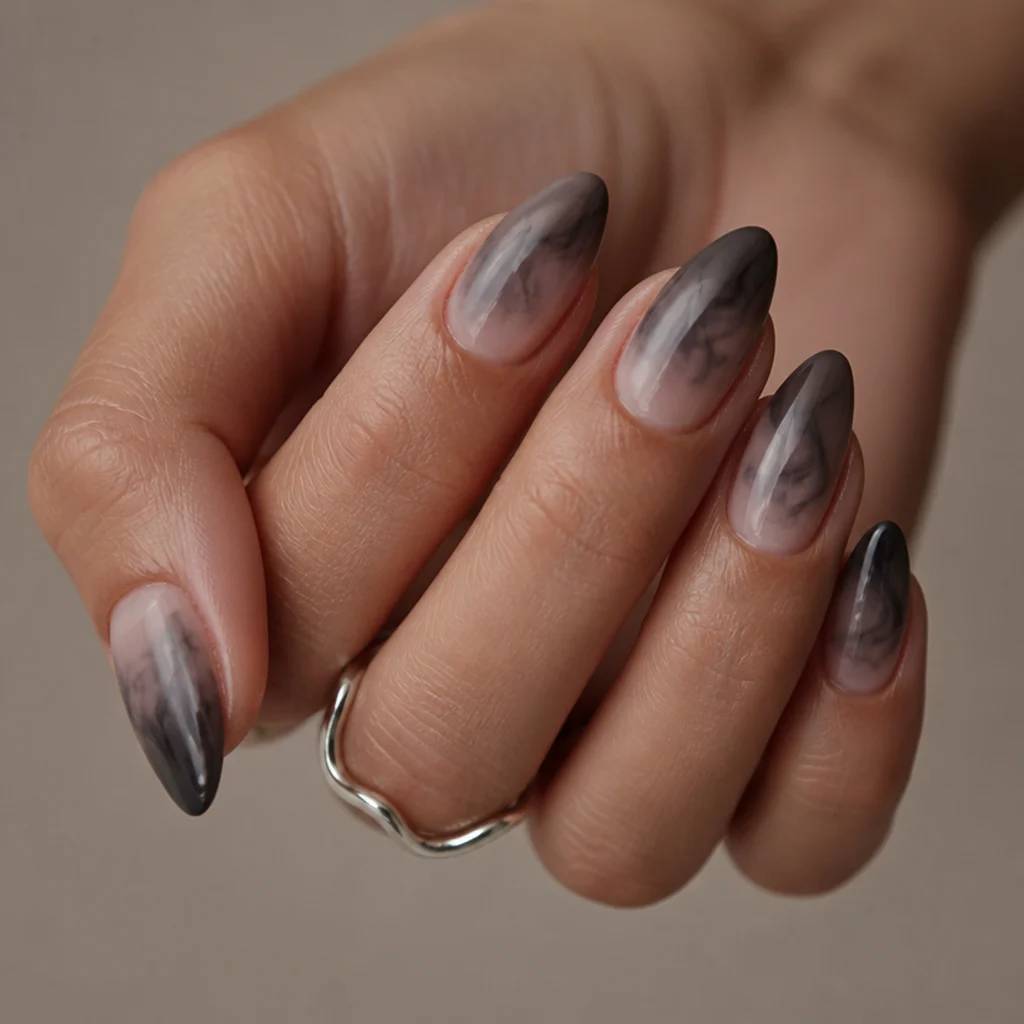 Almond nails with a smoky charcoal blooming gel haze concentrated at the tips, translucent and dissolving inward like smoke