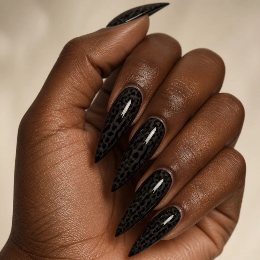 Long stiletto nails in glossy black leopard print with sharp pointed tips