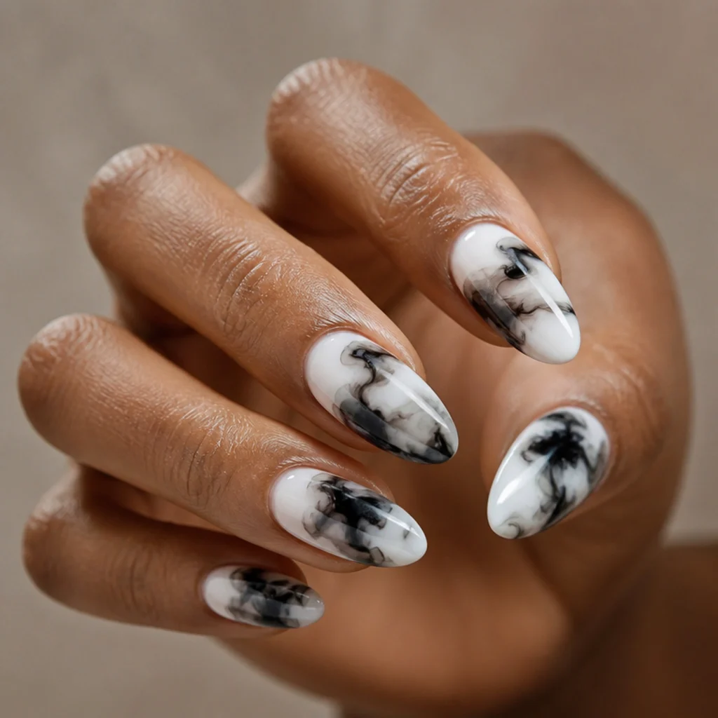 Almond nails with bold black and white blooming gel ink drops spreading into abstract shapes on a taupe background