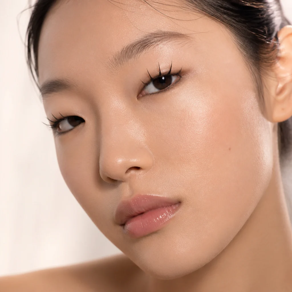 Monolid eyes with a spiky wet-look lash, glossy separated spikes fanning upward to cast shadow and add dimension to the flat lid