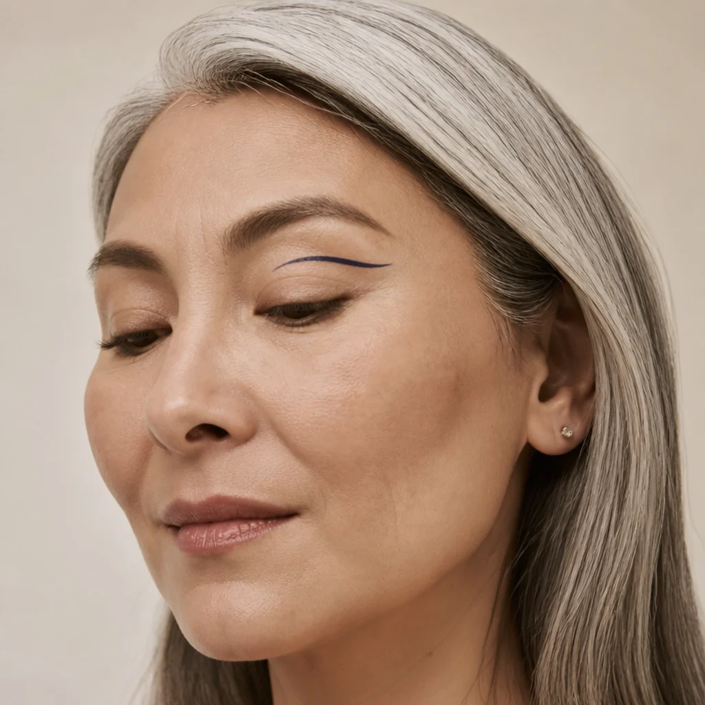 Close-up of a thin graphic floating liner drawn above the natural crease and lifted at the outer corner over a bare lid