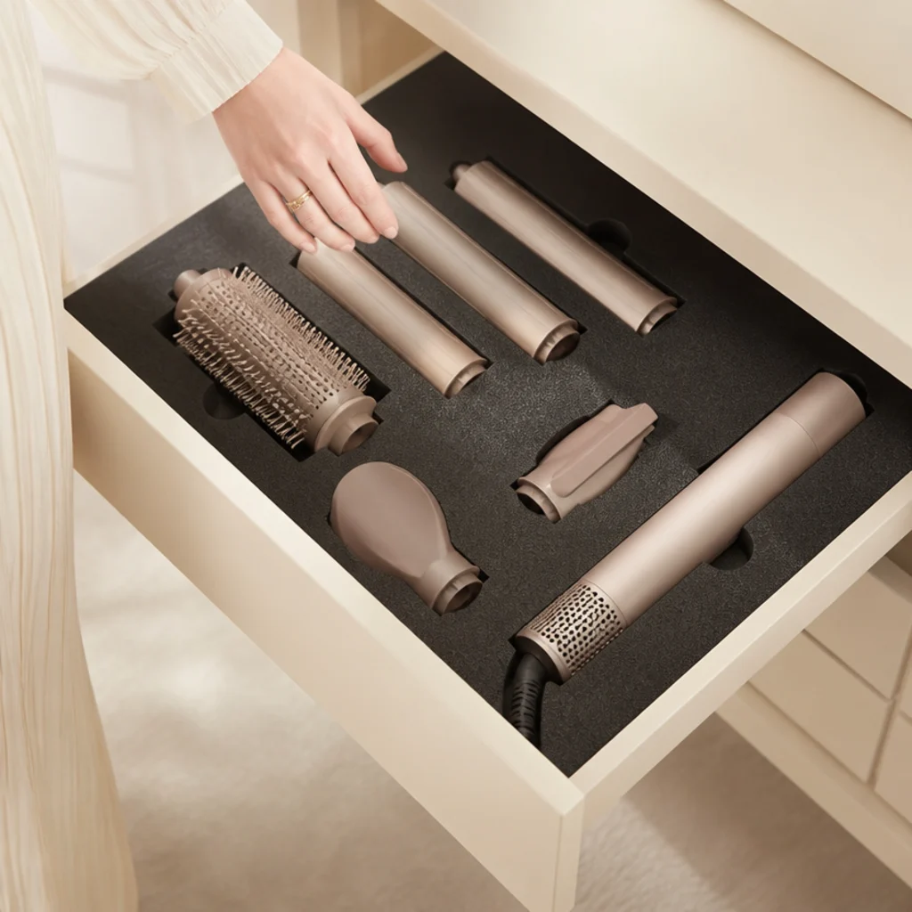 Vanity drawer lined with cut high-density foam holding each styling attachment in a snug cradle