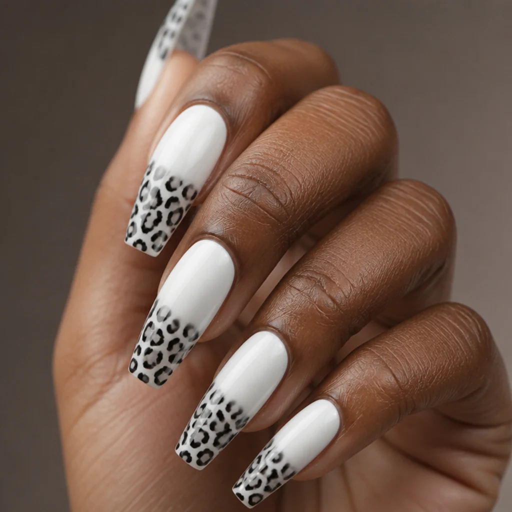 Long coffin nails with crisp white base and black and charcoal grey monochrome leopard spots at the tips